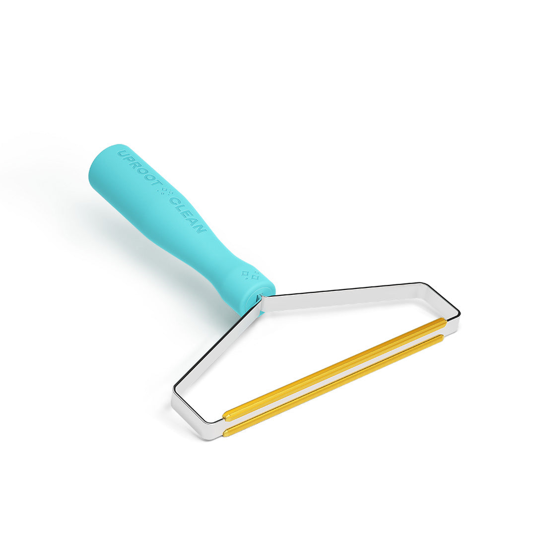 Turquoise Uproot Cleaner Pro fabric scraper with metal and gold scraping edges on a white background.