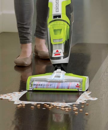 BISSELL manufacturer photo showing the CrossWave 1785A floor head and body during a floor-cleaning demonstration.