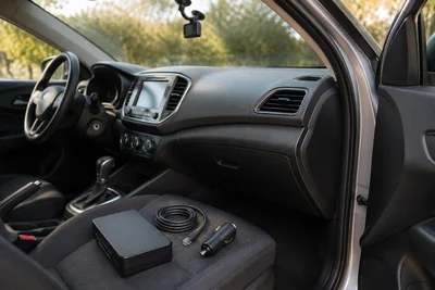 AI illustration of a dash-cam power pack, cable and accessory plug in a parked car.