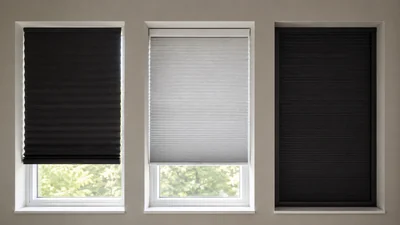 Three apartment windows compare a black temporary pleated shade, a white pressure-fit cellular shade, and a dark tracked blackout system.