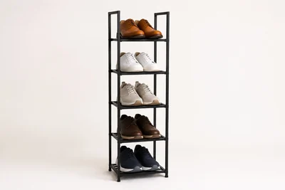 Original unbranded illustration of a narrow black five-tier vertical shoe tower holding five ordinary shoe pairs on an off-white background.
