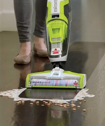 BISSELL manufacturer photo showing the CrossWave 1785A floor head and body during a floor-cleaning demonstration.